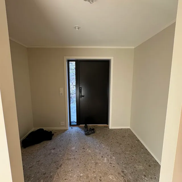 Inngangsparti med terrazzo-fliser og sort dør